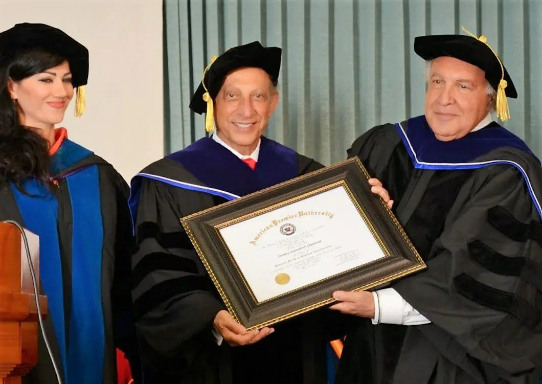 Three men in graduation robes holding a framed certificate.
